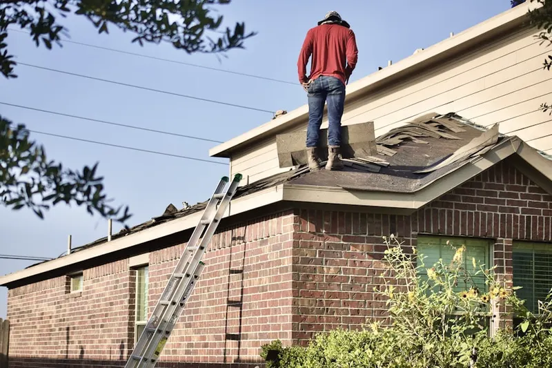 Professional roofer working on a residential roof in One Stop